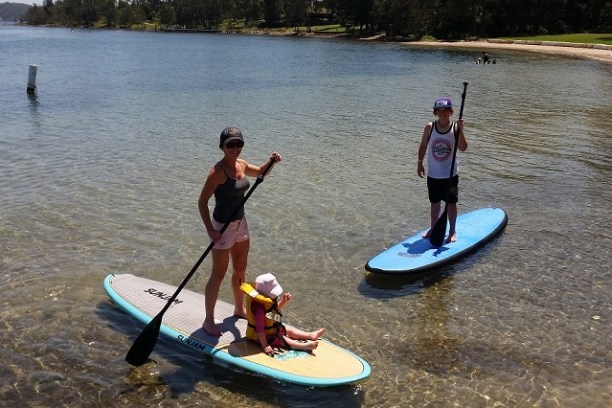 a group of people standing next to a body of water